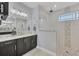 Modern bathroom features a vanity with double sinks and a glass-enclosed shower with decorative stone accents at 14286 Fort Worth Cir, Port Charlotte, FL 33981