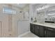 This stunning bathroom features a frameless glass shower, stone accents, and a modern vanity with great lighting at 14286 Fort Worth Cir, Port Charlotte, FL 33981