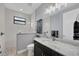 The bright bathroom has tile accents, a large mirror, great lighting, and a glass shower at 14286 Fort Worth Cir, Port Charlotte, FL 33981