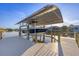 Modern boat dock with covered boat lift, blue boat, and wooden dock, perfect for waterfront living at 14286 Fort Worth Cir, Port Charlotte, FL 33981
