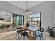 Dining area with table with chairs and plant life, sliding doors to the pool, and modern light fixture above table at 14286 Fort Worth Cir, Port Charlotte, FL 33981