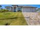 Charming home showcasing a paved driveway and well-maintained lawn, blending comfort and style at 14286 Fort Worth Cir, Port Charlotte, FL 33981