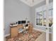 Bright home office featuring a patterned rug, a modern desk setup, and a large window for natural light at 14286 Fort Worth Cir, Port Charlotte, FL 33981