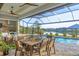 Relaxing outdoor screened-in patio with an outdoor kitchen, dining area, and a beautiful pool overlooking the water at 14286 Fort Worth Cir, Port Charlotte, FL 33981
