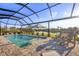 Relaxing pool area featuring a screened-in enclosure, sun umbrella, and tranquil water views at 14286 Fort Worth Cir, Port Charlotte, FL 33981