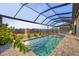Beautiful pool and water view surrounded by lush landscaping under a screened lanai at 14286 Fort Worth Cir, Port Charlotte, FL 33981
