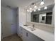 Modern bathroom vanity with storage and a large mirror with bright lighting at 150 Englewood Isles Pkwy # 201, Englewood, FL 34223