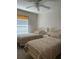 Cozy bedroom with two twin beds, a ceiling fan, and natural light at 150 Englewood Isles Pkwy # 201, Englewood, FL 34223
