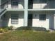 Close-up of unit 201 with a small, manicured yard, windows, and a dark brown front door at 150 Englewood Isles Pkwy # 201, Englewood, FL 34223