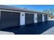 View of the gray garage doors, each numbered, and the black asphalt driveway at 150 Englewood Isles Pkwy # 201, Englewood, FL 34223