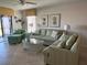 Bright living room with tile floors, comfortable green furniture, and stylish decor accents at 150 Englewood Isles Pkwy # 201, Englewood, FL 34223