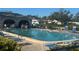 Community pool featuring ample seating and lush landscaping, with people enjoying the amenities at 150 Englewood Isles Pkwy # 201, Englewood, FL 34223