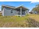 Spacious yard showing the home's covered patio with seating area and well-kept lawn at 15251 Appleton Blvd, Port Charlotte, FL 33981