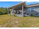 Backyard view of a covered patio extending from the house into the grassy yard at 15251 Appleton Blvd, Port Charlotte, FL 33981