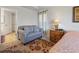 Comfortable bedroom featuring a cozy loveseat, neutral walls, and stylish decor at 15251 Appleton Blvd, Port Charlotte, FL 33981
