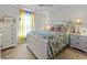 Light, bright bedroom featuring a floral bedspread, wood floors, and large windows at 15251 Appleton Blvd, Port Charlotte, FL 33981