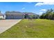 Charming single-story home featuring a three-car garage and well-manicured lawn with beautiful landscaping at 15251 Appleton Blvd, Port Charlotte, FL 33981