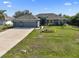 Well maintained home with a three car garage, an inviting entrance and a verdant, manicured front yard at 15251 Appleton Blvd, Port Charlotte, FL 33981