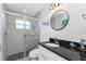 Bathroom with glass enclosed shower, modern fixtures, and beach-themed decorations at 15738 Applewhite Cir, Port Charlotte, FL 33981
