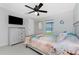 Bright bedroom with ceiling fan, a wall-mounted TV, and a coastal-themed bed at 15738 Applewhite Cir, Port Charlotte, FL 33981