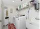 Functional laundry room with modern appliances, ample shelving, and a utility sink at 15738 Applewhite Cir, Port Charlotte, FL 33981