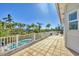 Expansive outdoor deck overlooking the pool and backyard with palm trees, perfect for entertaining at 16251 Sunset Pines Cir, Boca Grande, FL 33921