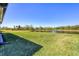 Expansive backyard featuring lush green grass and a tranquil lake view, creating a serene outdoor space for relaxation at 1758 Saddlewood Cir, Port Charlotte, FL 33953