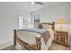 Bright bedroom featuring a wooden bed frame, ceiling fan, and view to an ensuite bathroom at 1758 Saddlewood Cir, Port Charlotte, FL 33953