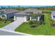 Charming home with lush landscaping, brick paved driveway, and beautiful lake view in the background at 1758 Saddlewood Cir, Port Charlotte, FL 33953