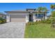 Inviting home featuring a well-manicured lawn, brick paved driveway, and covered front entryway at 1758 Saddlewood Cir, Port Charlotte, FL 33953