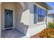 Welcoming front entrance with a stylish door, decorative wreath, and colorful landscaping accents at 1758 Saddlewood Cir, Port Charlotte, FL 33953