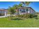 Beautifully landscaped front yard with vibrant flowers, lush greenery, and a well-maintained lawn at 1758 Saddlewood Cir, Port Charlotte, FL 33953