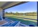 Relaxing screened-in lanai offers a tranquil view of the pond and scenic landscape at 1758 Saddlewood Cir, Port Charlotte, FL 33953