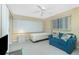 Relaxing bedroom featuring soft carpet, ceiling fan, comfy blue loveseat and bright natural light at 2 Bunker Way, Rotonda West, FL 33947