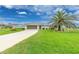 Well-manicured front yard with a mature palm tree in front of this single-story home at 2 Bunker Way, Rotonda West, FL 33947