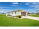 Home exterior featuring a well-kept lawn and manicured landscaping at 2 Bunker Way, Rotonda West, FL 33947