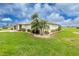 Landscaped home exterior with lush green lawn and mature palm trees at 2 Bunker Way, Rotonda West, FL 33947