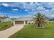 Charming single-story home featuring a well-maintained lawn and a decorative palm tree at 2 Bunker Way, Rotonda West, FL 33947