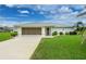 Charming single-story home featuring a two-car garage, well-manicured lawn, and beautiful landscaping at 2 Bunker Way, Rotonda West, FL 33947