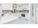 Well-maintained kitchen with white cabinetry, smooth countertops, and tiled flooring at 2 Bunker Way, Rotonda West, FL 33947