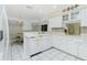 Clean kitchen with white cabinets, tile floors, breakfast bar and decorative accents at 2 Bunker Way, Rotonda West, FL 33947