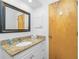 Bathroom featuring granite vanity with a decorative mirror and white cabinetry at 20 Bunker Way, Rotonda West, FL 33947