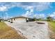Exterior back of the property with crushed shells for ground covering, landscaping, and screened pool at 20 Bunker Way, Rotonda West, FL 33947