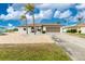 Single story home with white exterior, rock garden, brown roof and attached garage at 20 Bunker Way, Rotonda West, FL 33947