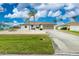 Charming single-story home featuring a well-manicured lawn, palm trees, and an attached two-car garage at 20 Bunker Way, Rotonda West, FL 33947