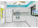Bright kitchen featuring white cabinetry, tile floors and matching white appliances at 20 Bunker Way, Rotonda West, FL 33947