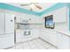 Bright kitchen featuring white cabinetry, tile floors and matching white appliances at 20 Bunker Way, Rotonda West, FL 33947