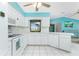 White kitchen with matching appliances, tile flooring, and views into the adjacent living room at 20 Bunker Way, Rotonda West, FL 33947
