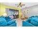 Cozy living room with plush sofas, ceiling fan, and sliding glass doors leading to the pool area at 20 Bunker Way, Rotonda West, FL 33947