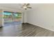 Bright bedroom with wood-look floors and sliding glass doors leading to a screened lanai at 200 Rotonda W Blvd # A2, Rotonda West, FL 33947